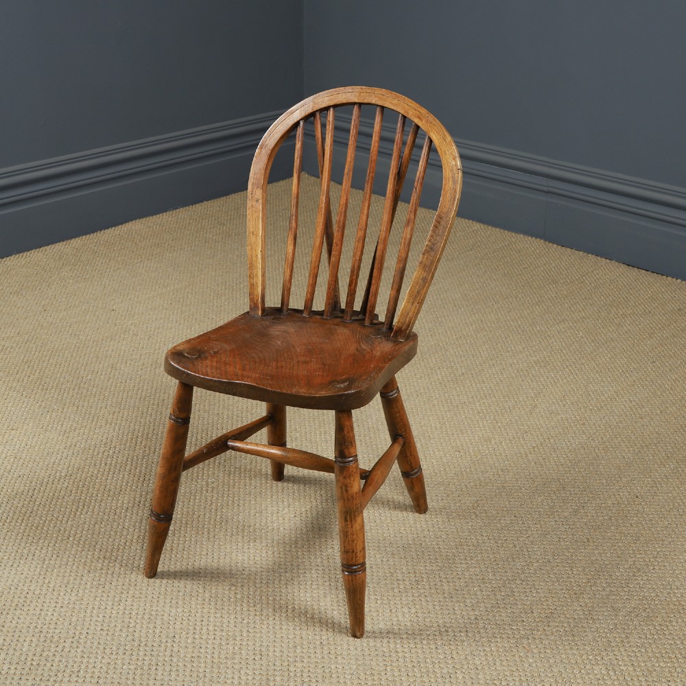 A set of eight antique Edwardian ash and elm Windsor dining chairs with arched hoop stick backs, shaped seats, and turned legs. View X