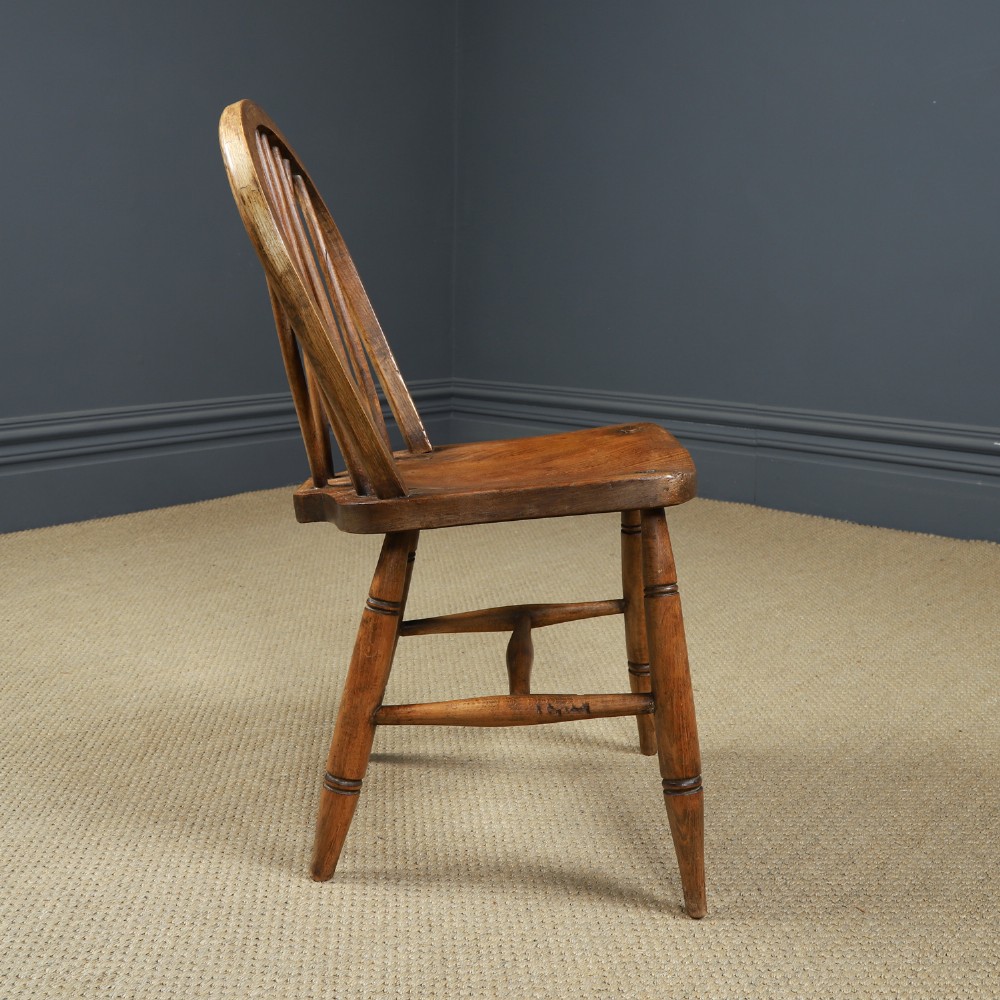 A set of eight antique Edwardian ash and elm Windsor dining chairs with arched hoop stick backs, shaped seats, and turned legs. View XII