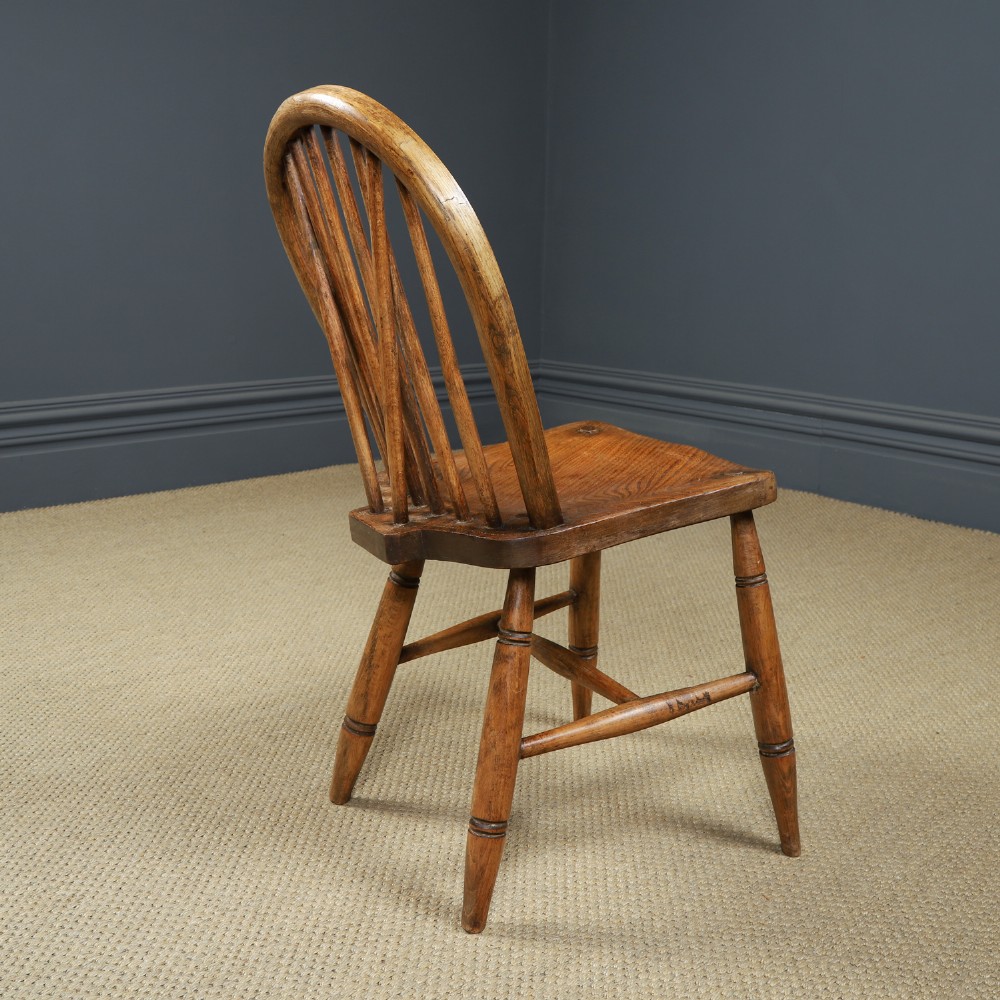 A set of eight antique Edwardian ash and elm Windsor dining chairs with arched hoop stick backs, shaped seats, and turned legs. View XIII