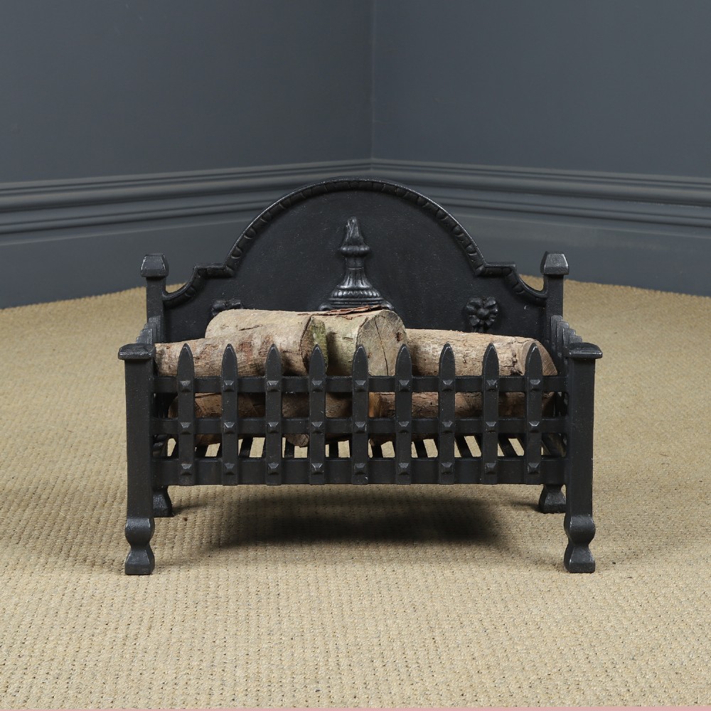 A black cast iron open fire grate featuring an arched backplate decorated with an urn relief and a palisade front basket resting on four square legs. View II