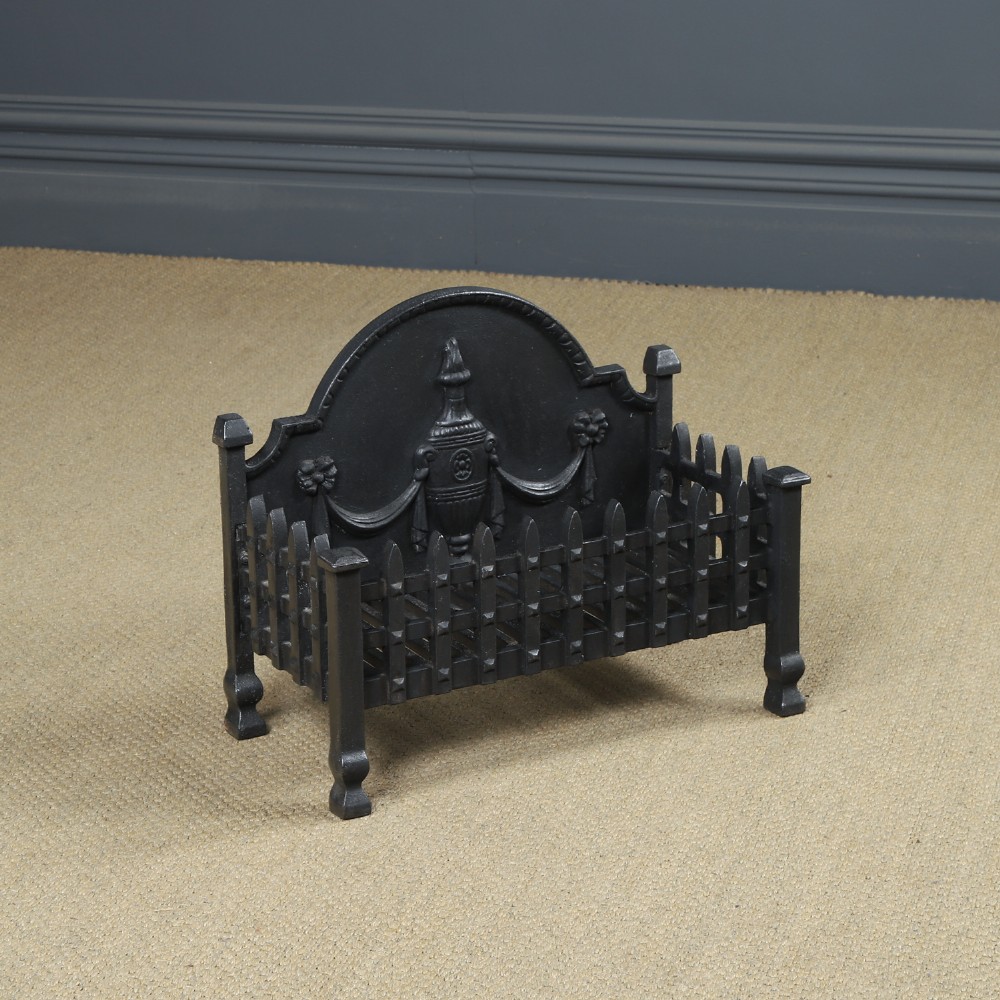 A black cast iron open fire grate featuring an arched backplate decorated with an urn relief and a palisade front basket resting on four square legs. View III