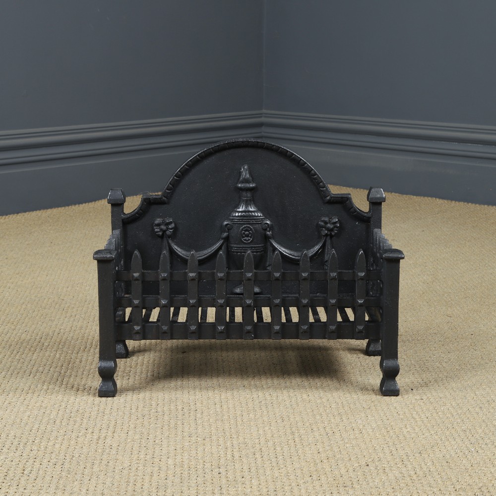 A black cast iron open fire grate featuring an arched backplate decorated with an urn relief and a palisade front basket resting on four square legs. View IV