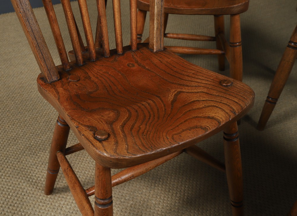 A set of four antique English warm brown ash and elm Windsor dining chairs featuring hoop backs, stick spindles, and turned legs. View III