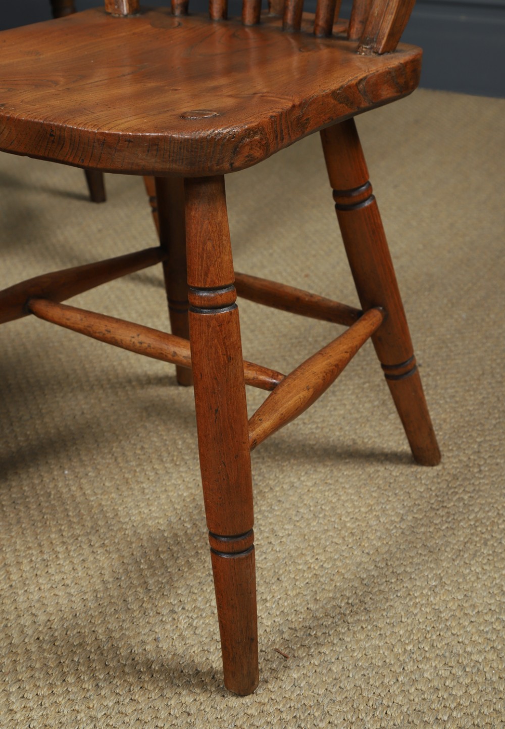 A set of four antique English warm brown ash and elm Windsor dining chairs featuring hoop backs, stick spindles, and turned legs. View IV