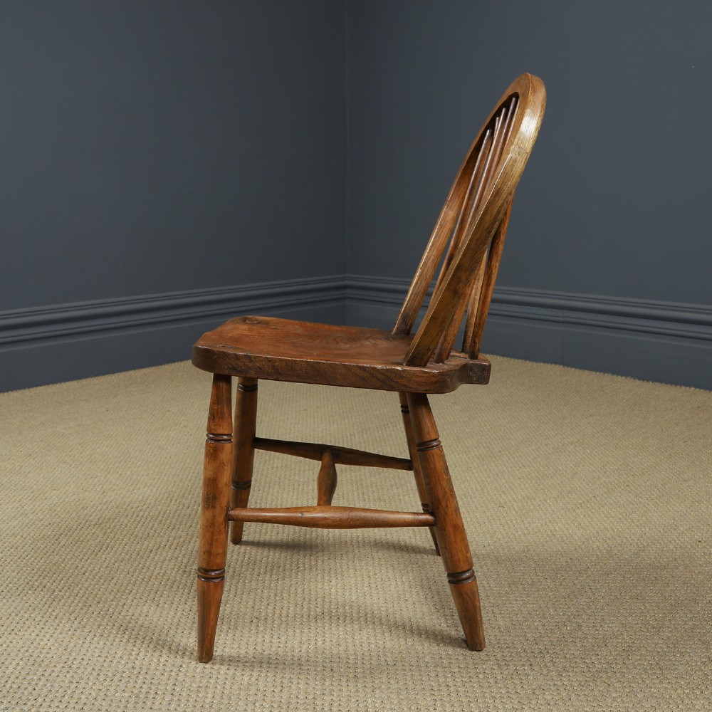 A set of four antique English warm brown ash and elm Windsor dining chairs featuring hoop backs, stick spindles, and turned legs. View VI