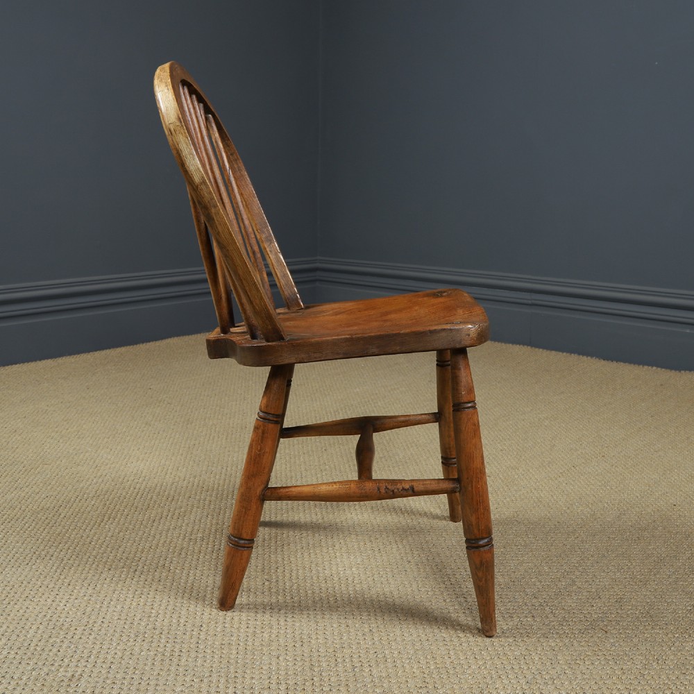 A set of four antique English warm brown ash and elm Windsor dining chairs featuring hoop backs, stick spindles, and turned legs. View IX