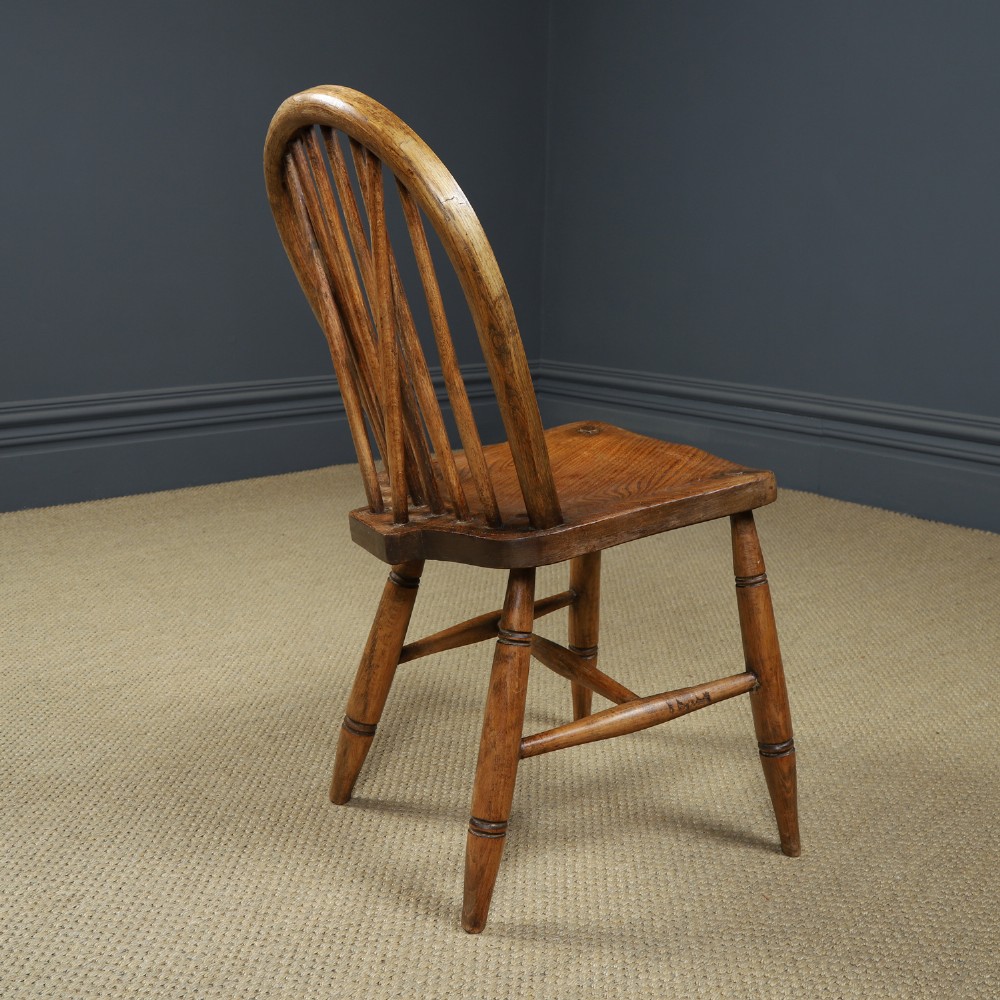 A set of four antique English warm brown ash and elm Windsor dining chairs featuring hoop backs, stick spindles, and turned legs. View XI