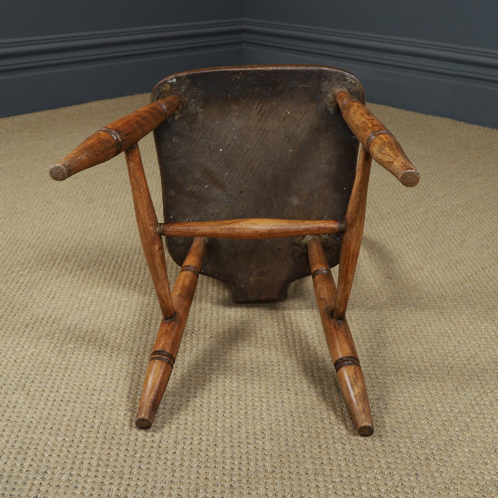 A set of four antique English warm brown ash and elm Windsor dining chairs featuring hoop backs, stick spindles, and turned legs. View XII