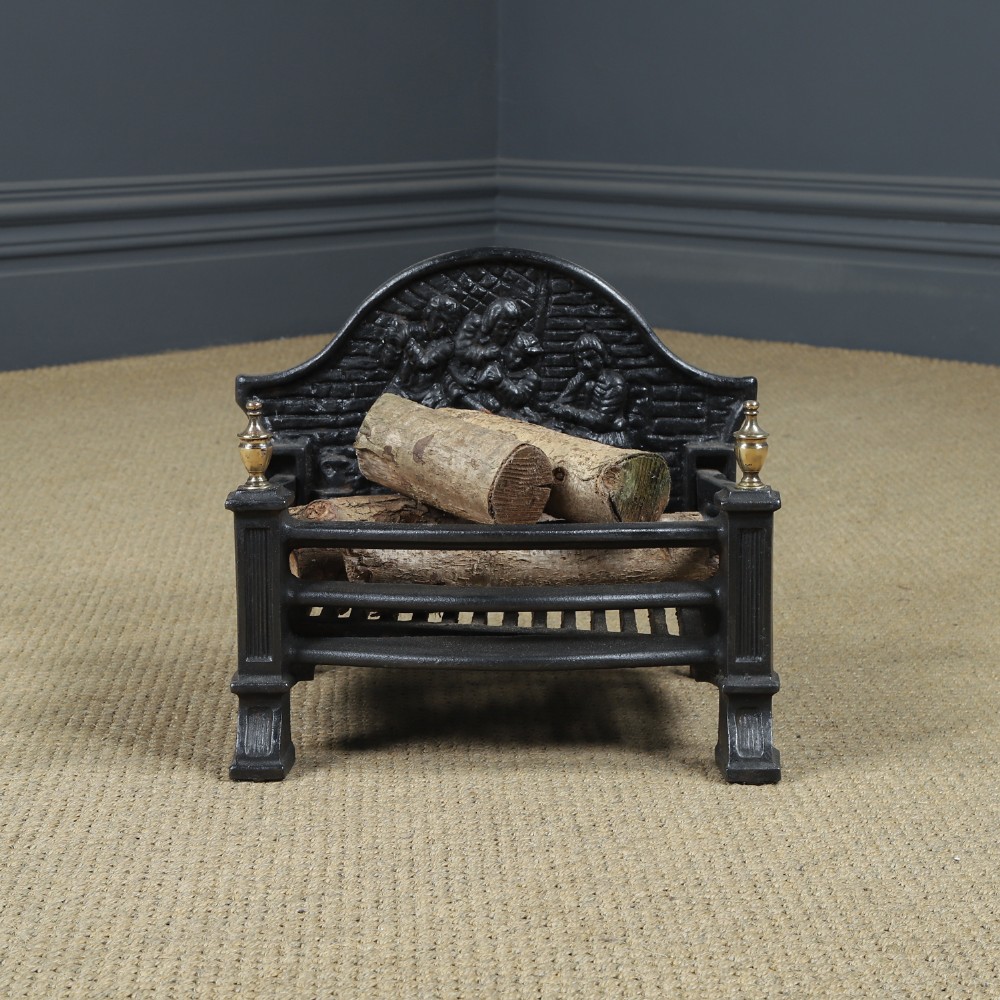 A black cast iron fire grate featuring an arched pictorial backplate, curved front bars, and brass urn finials on the front posts. View II