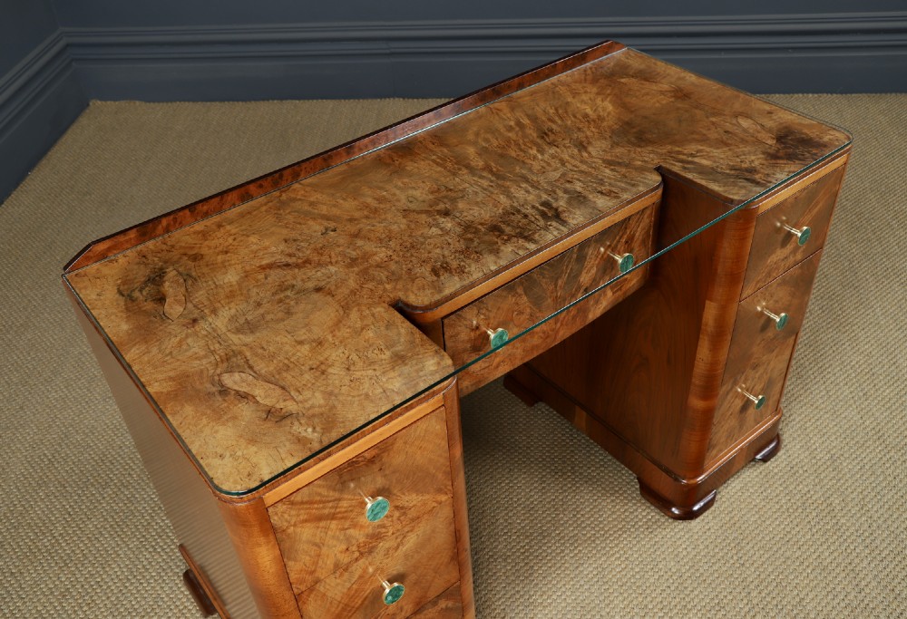 An Art Deco burr walnut pedestal writing desk with green circular knobs and a fitted glass top. View VI
