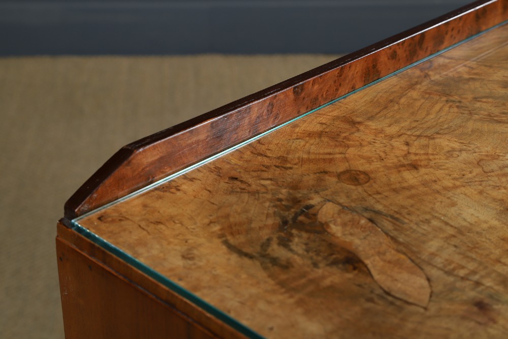An Art Deco burr walnut pedestal writing desk with green circular knobs and a fitted glass top. View VII