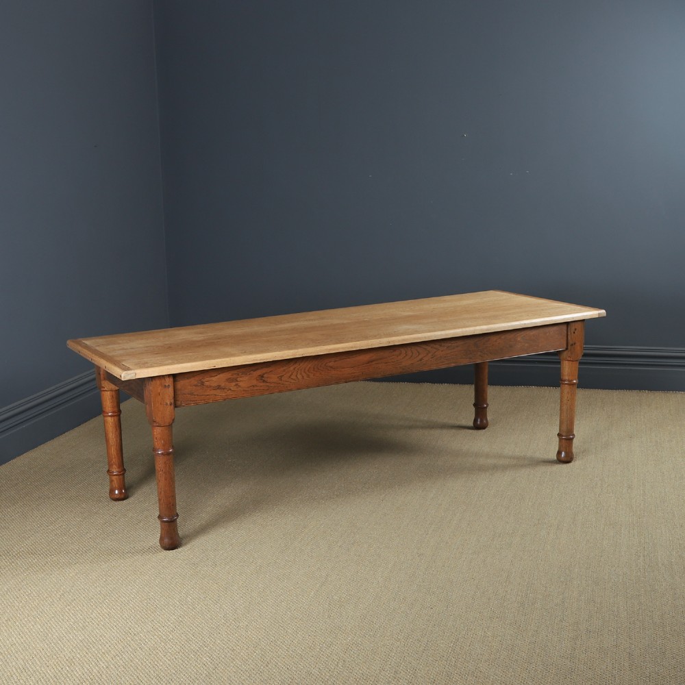 A long Victorian 19th-century refectory dining table with a light pitch pine top and dark oak frame on turned legs.
