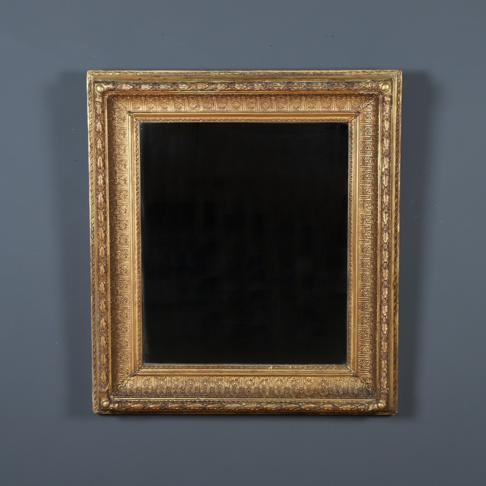 A rectangular Victorian gilt wall mirror featuring a moulded frame with classical leaf and beaded details.