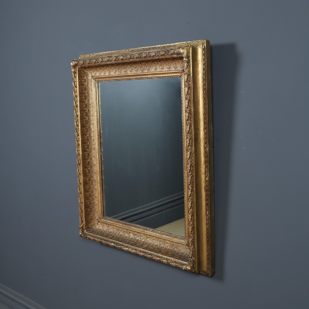 A rectangular Victorian gilt wall mirror featuring a moulded frame with classical leaf and beaded details. View II