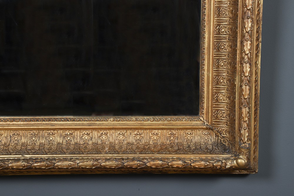 A rectangular Victorian gilt wall mirror featuring a moulded frame with classical leaf and beaded details. View V