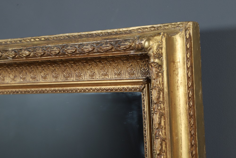 A rectangular Victorian gilt wall mirror featuring a moulded frame with classical leaf and beaded details. View VII