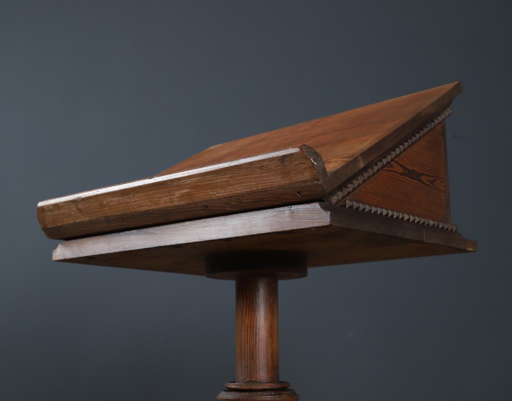 An antique Victorian pitch pine lectern featuring a slanted book rest, turned central column, and a Gothic-style pedestal base. View III