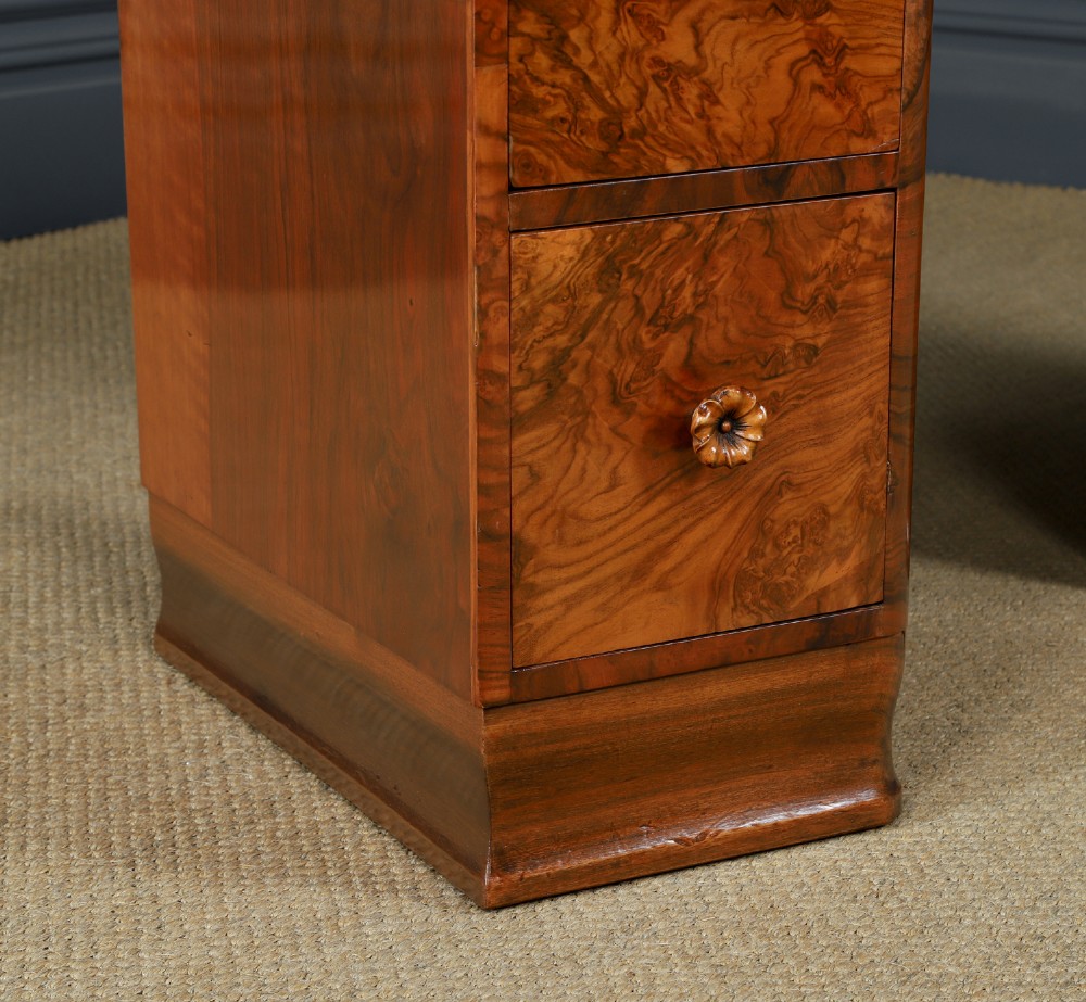 A pair of narrow Art Deco burr walnut bedside cabinets featuring two drawers with carved circular handles and a low back ledge. View III