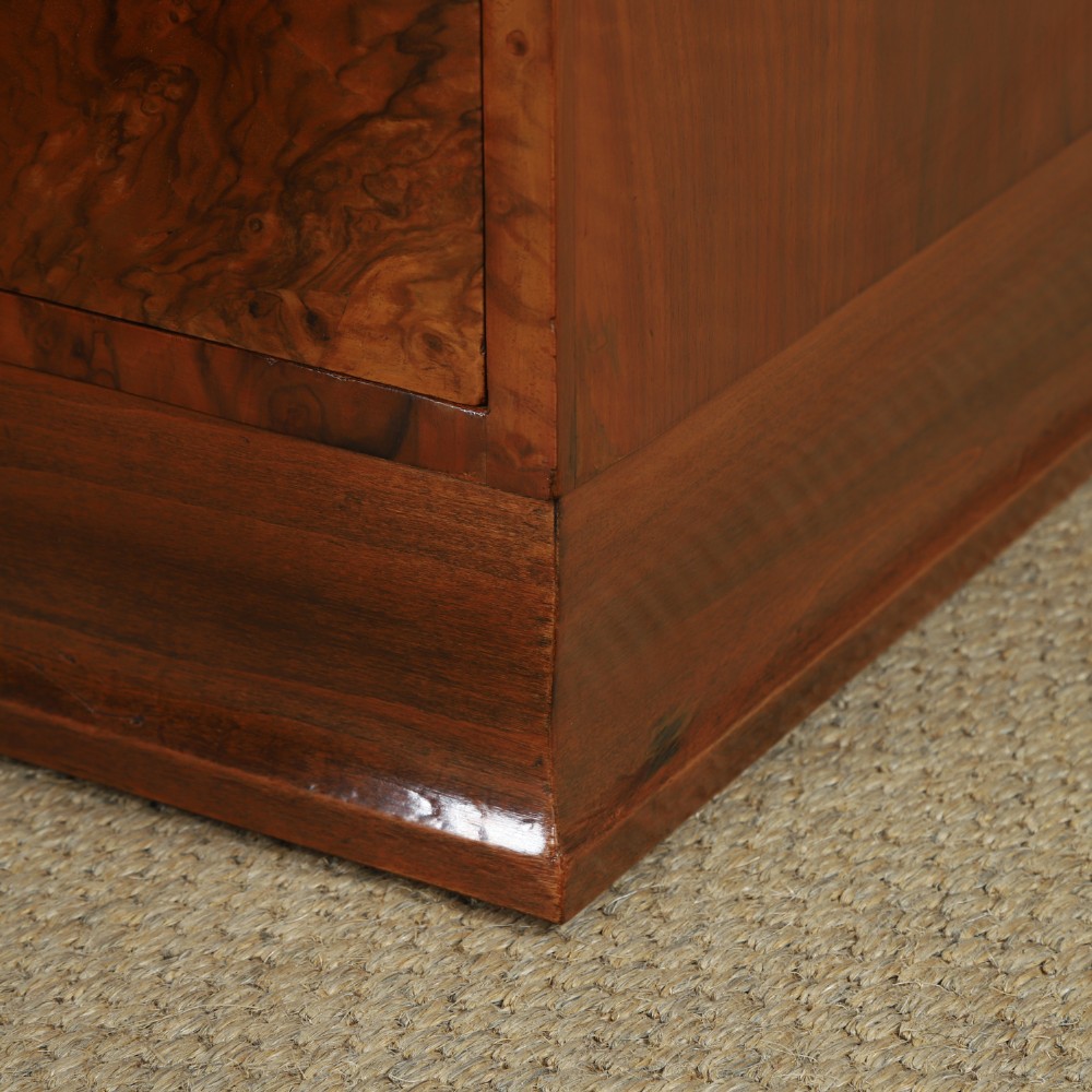 A pair of narrow Art Deco burr walnut bedside cabinets featuring two drawers with carved circular handles and a low back ledge. View V