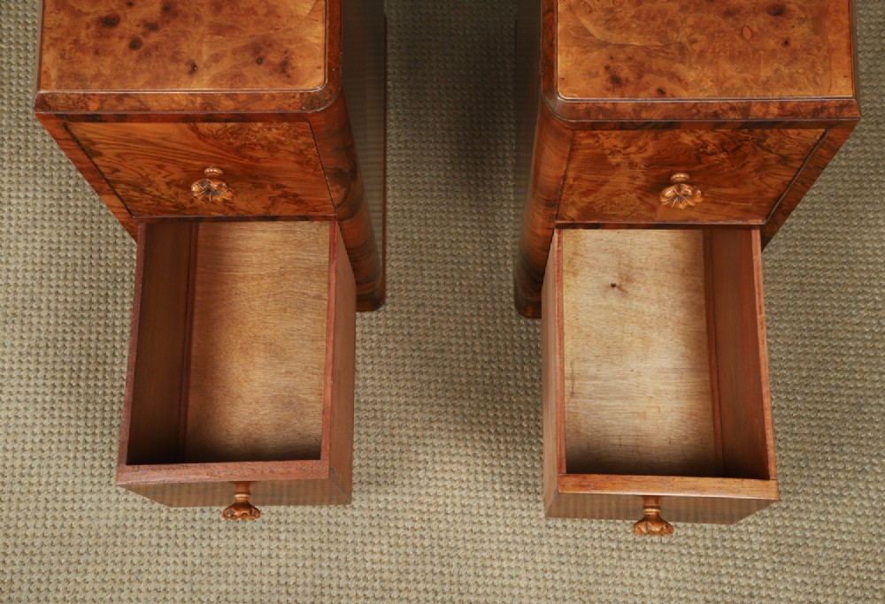 A pair of narrow Art Deco burr walnut bedside cabinets featuring two drawers with carved circular handles and a low back ledge. View XII