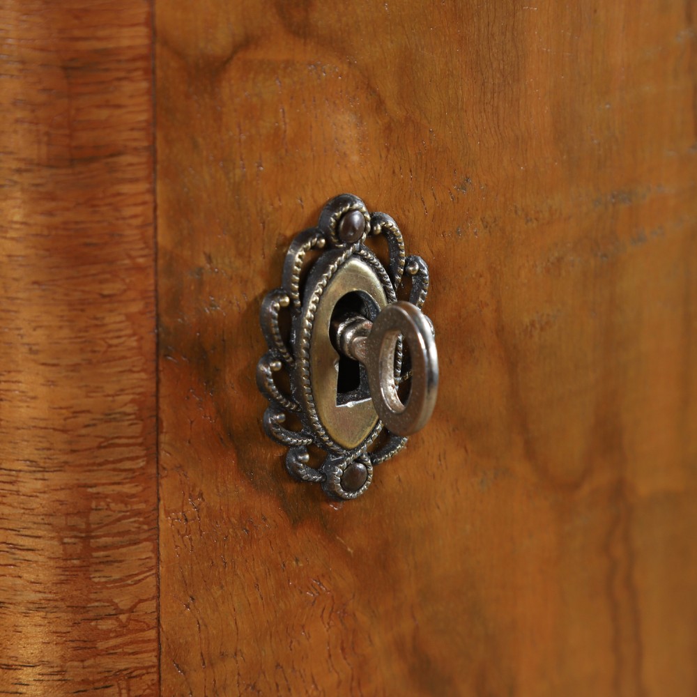 An Art Deco walnut two door wardrobe featuring a bow front design, carved wood handles, and figured timber grain. View IV