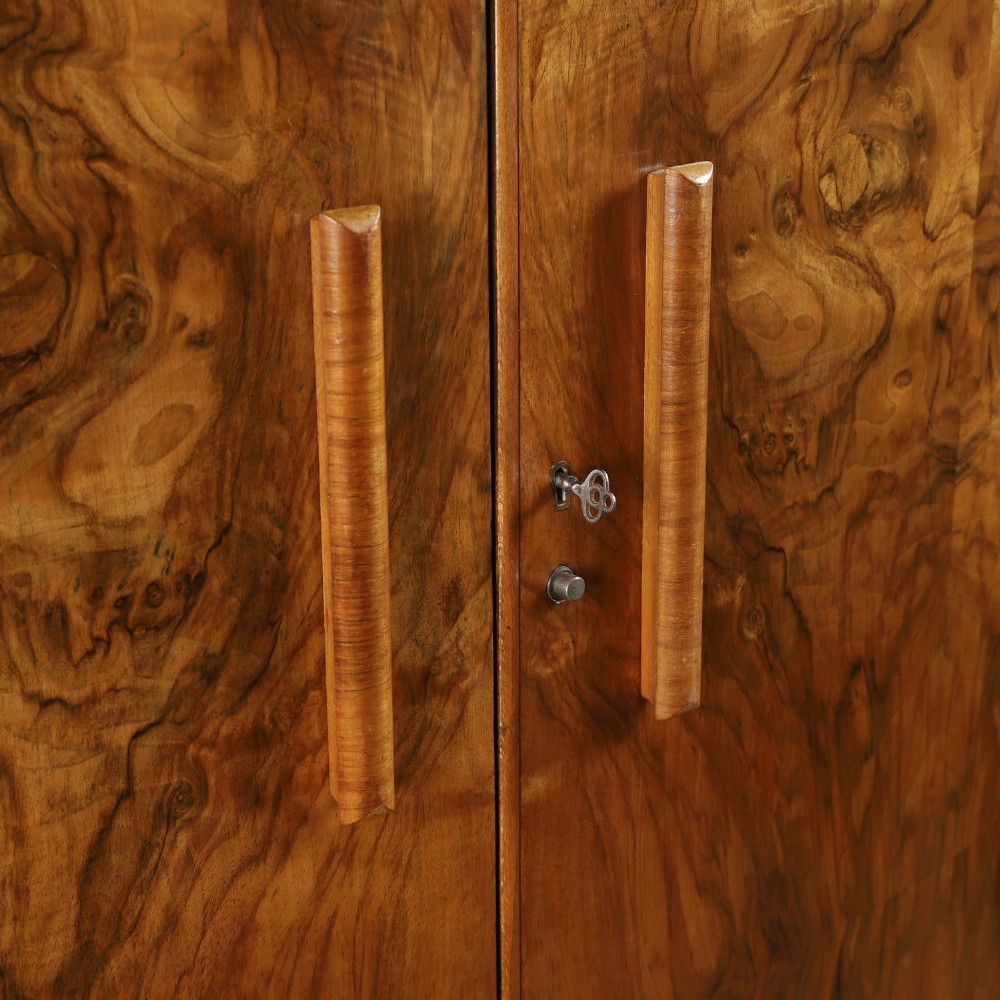 An Art Deco two door wardrobe crafted from warm brown figured walnut veneer with a gently curved bow front and wooden vertical handles. View V