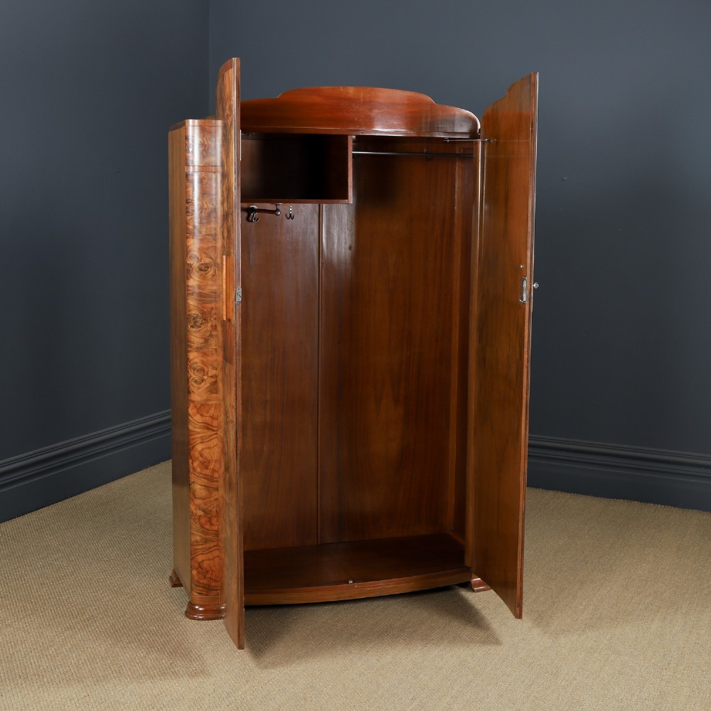 An Art Deco two door wardrobe crafted from warm brown figured walnut veneer with a gently curved bow front and wooden vertical handles. View VIII
