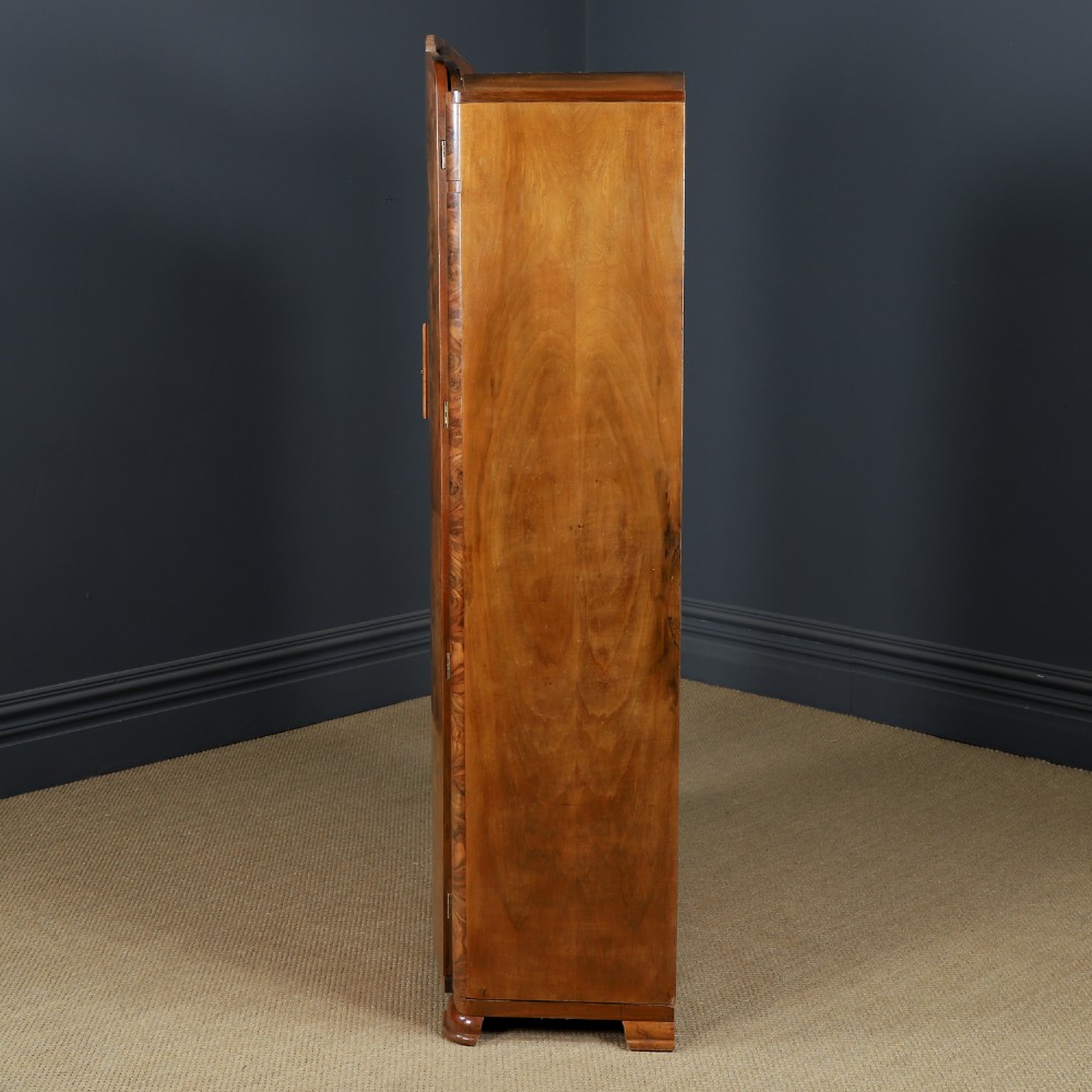 An Art Deco two door wardrobe crafted from warm brown figured walnut veneer with a gently curved bow front and wooden vertical handles. View XII
