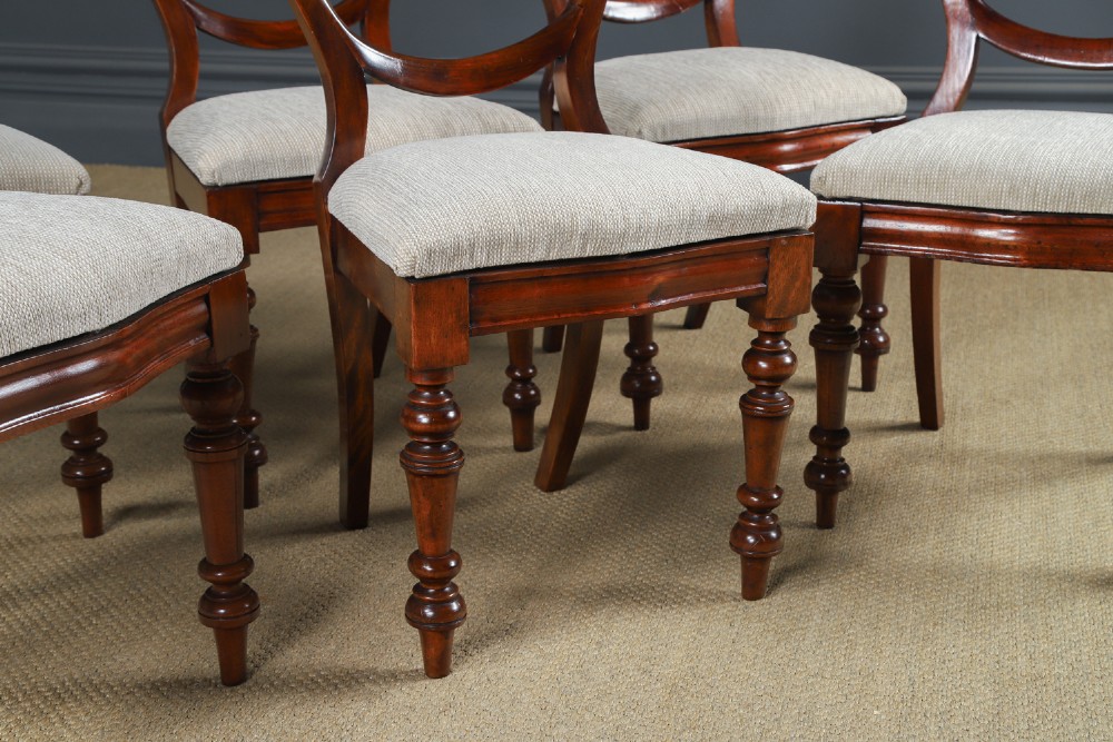 A set of six Victorian mahogany dining chairs featuring open balloon-shaped backs, turned front legs, and neutral upholstered seats. View V