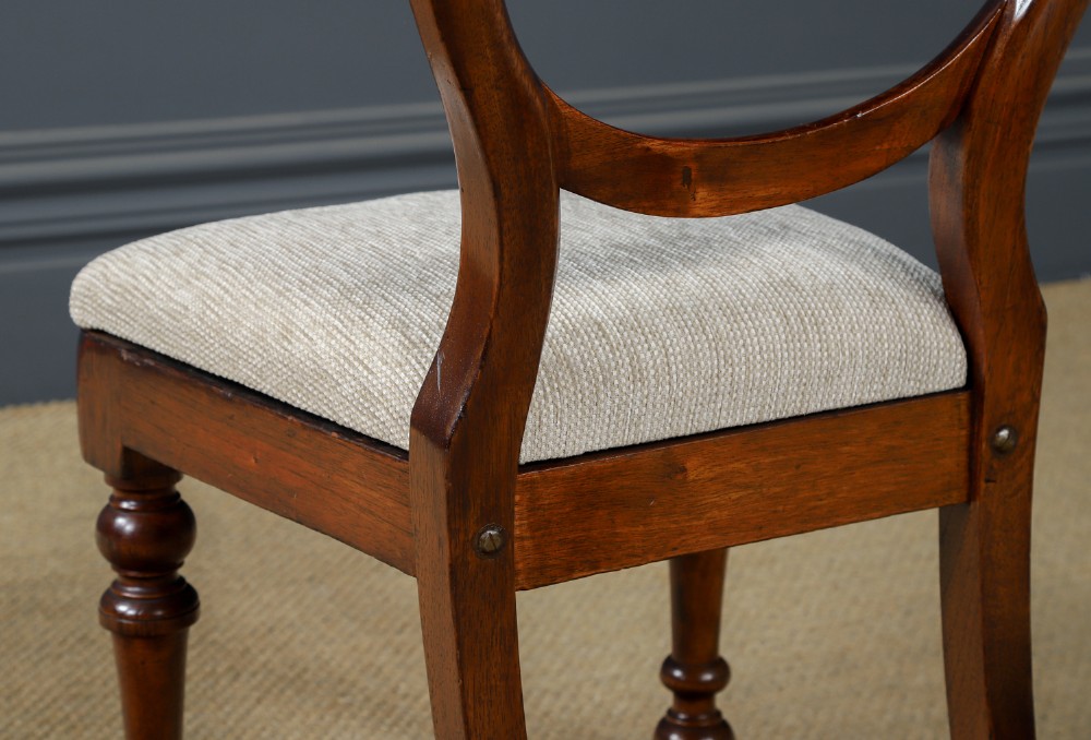 A set of six Victorian mahogany dining chairs featuring open balloon-shaped backs, turned front legs, and neutral upholstered seats. View X
