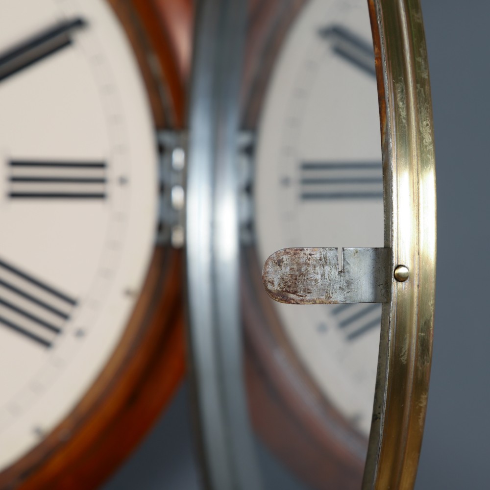 An antique Smiths circular wall clock with a turned mahogany surround, off-white dial plate, black Roman numerals, and brass bezel. View IX