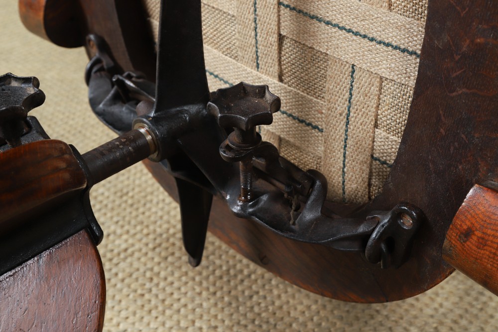 An Edwardian oak revolving desk armchair featuring a carved pierced back splat, green leather upholstered seat with close studding, and a four-point swivel base on brass castors. View XV