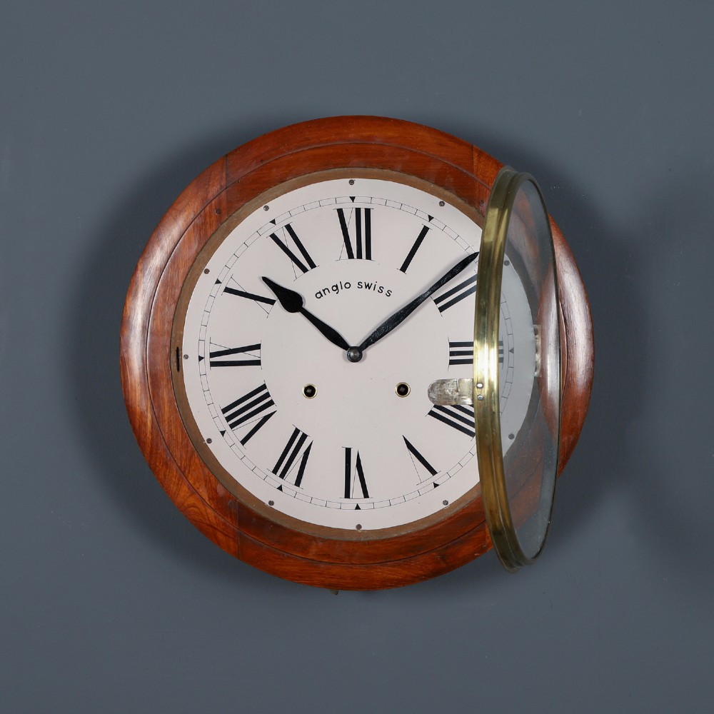 A circular antique wall clock featuring a turned mahogany frame, brass bezel, and white dial with black Roman numerals marked Anglo Swiss. View II