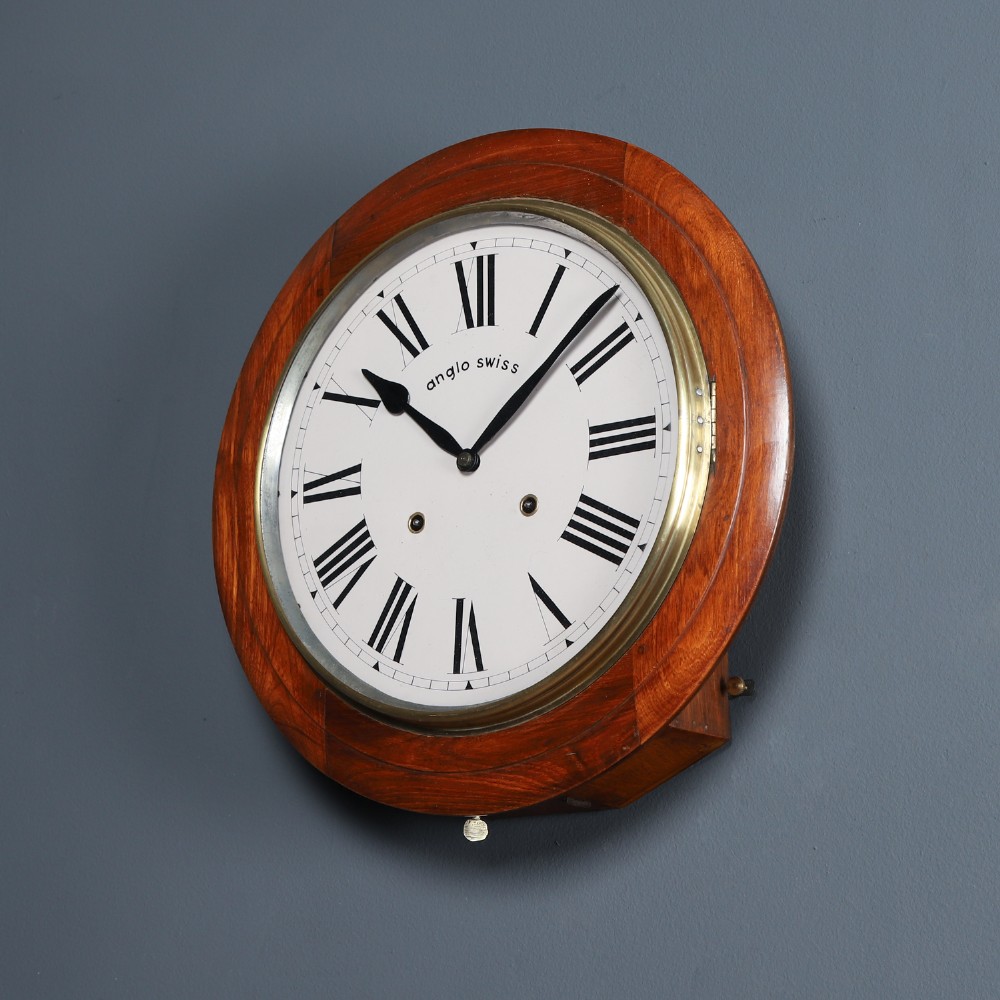 A circular antique wall clock featuring a turned mahogany frame, brass bezel, and white dial with black Roman numerals marked Anglo Swiss. View VIII