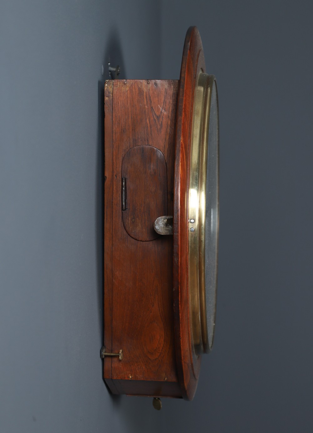 A circular antique wall clock featuring a turned mahogany frame, brass bezel, and white dial with black Roman numerals marked Anglo Swiss. View IX