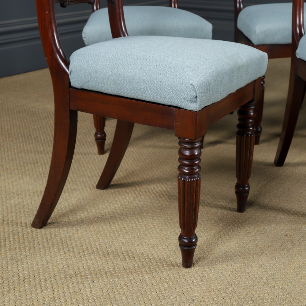A set of six antique mahogany dining chairs featuring curved top rails, carved horizontal splats, fluted turned front legs, and light blue upholstered seats. View II