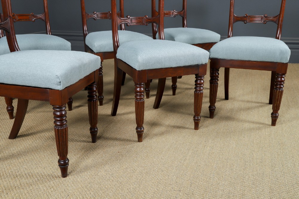 A set of six antique mahogany dining chairs featuring curved top rails, carved horizontal splats, fluted turned front legs, and light blue upholstered seats. View III