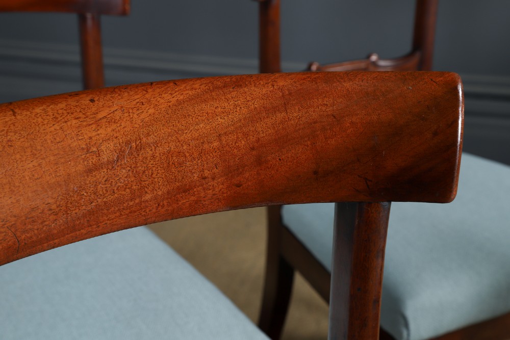 A set of six antique mahogany dining chairs featuring curved top rails, carved horizontal splats, fluted turned front legs, and light blue upholstered seats. View VI