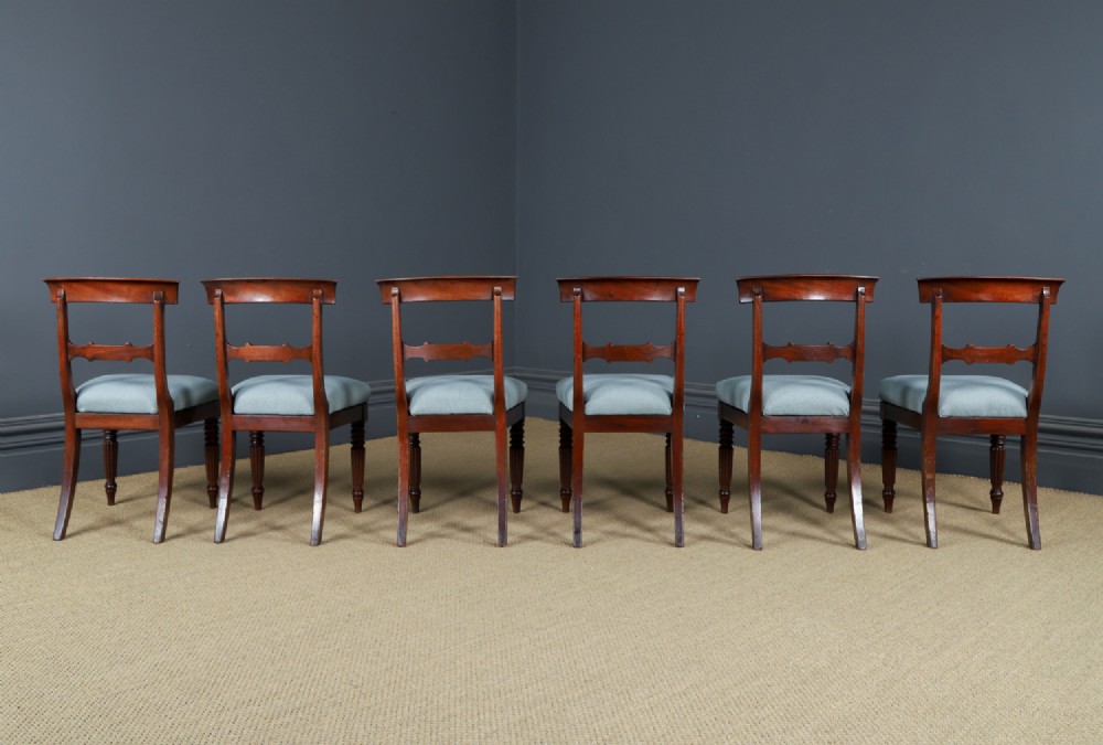 A set of six antique mahogany dining chairs featuring curved top rails, carved horizontal splats, fluted turned front legs, and light blue upholstered seats. View XII