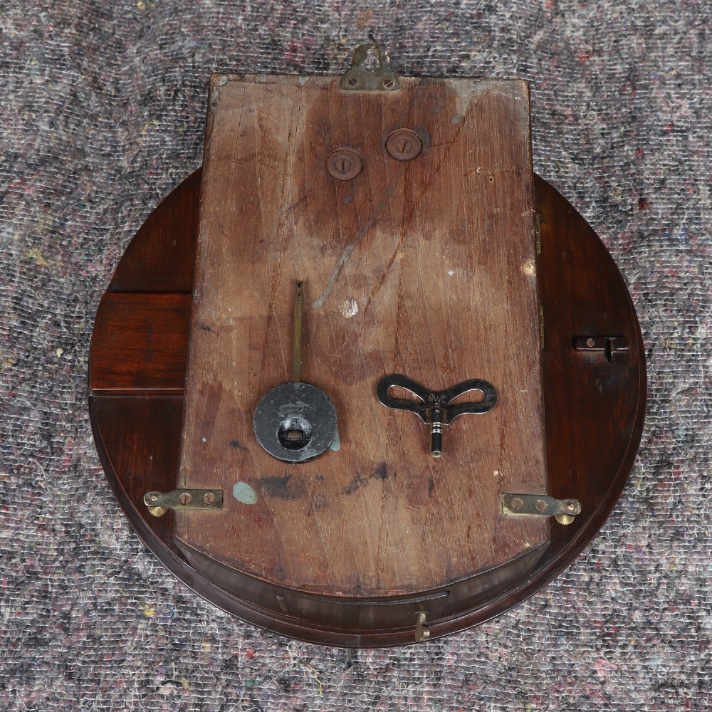 A circular mahogany wall clock with a cream dial, black Arabic numerals, black metal hands, two brass winding holes, and the Enfield maker name printed in the centre. View XIII