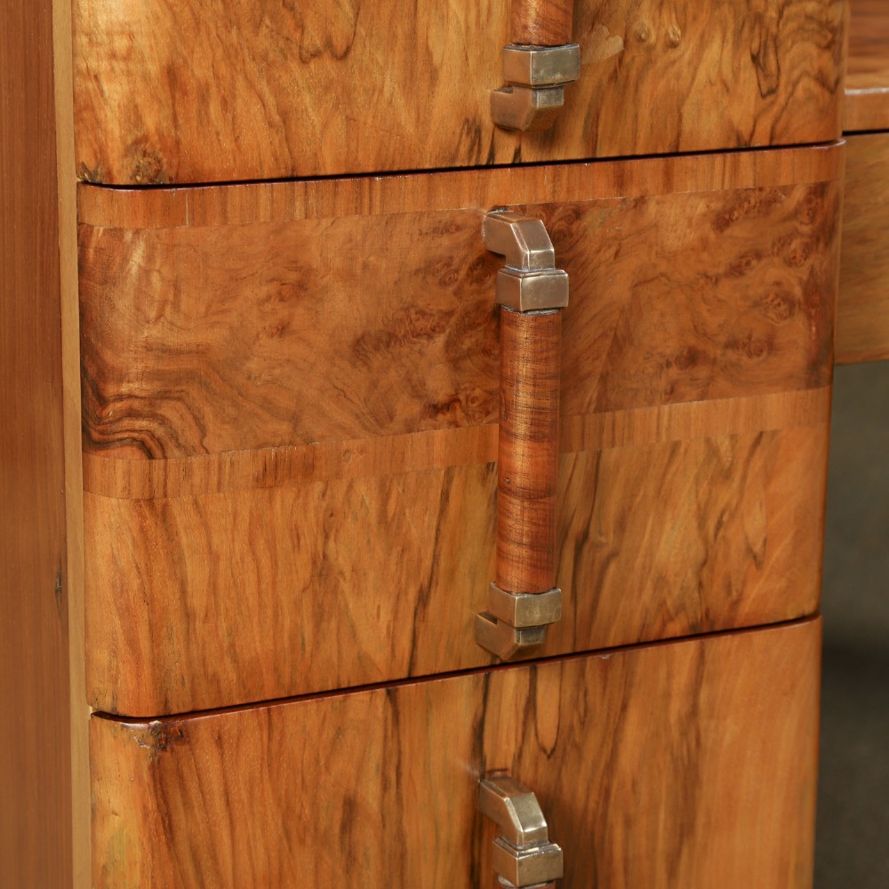 An Art Deco burr walnut pedestal dressing table featuring a large circular central mirror, a kneehole drawer, and three stacked drawers on each pedestal with vertical handles. View IV