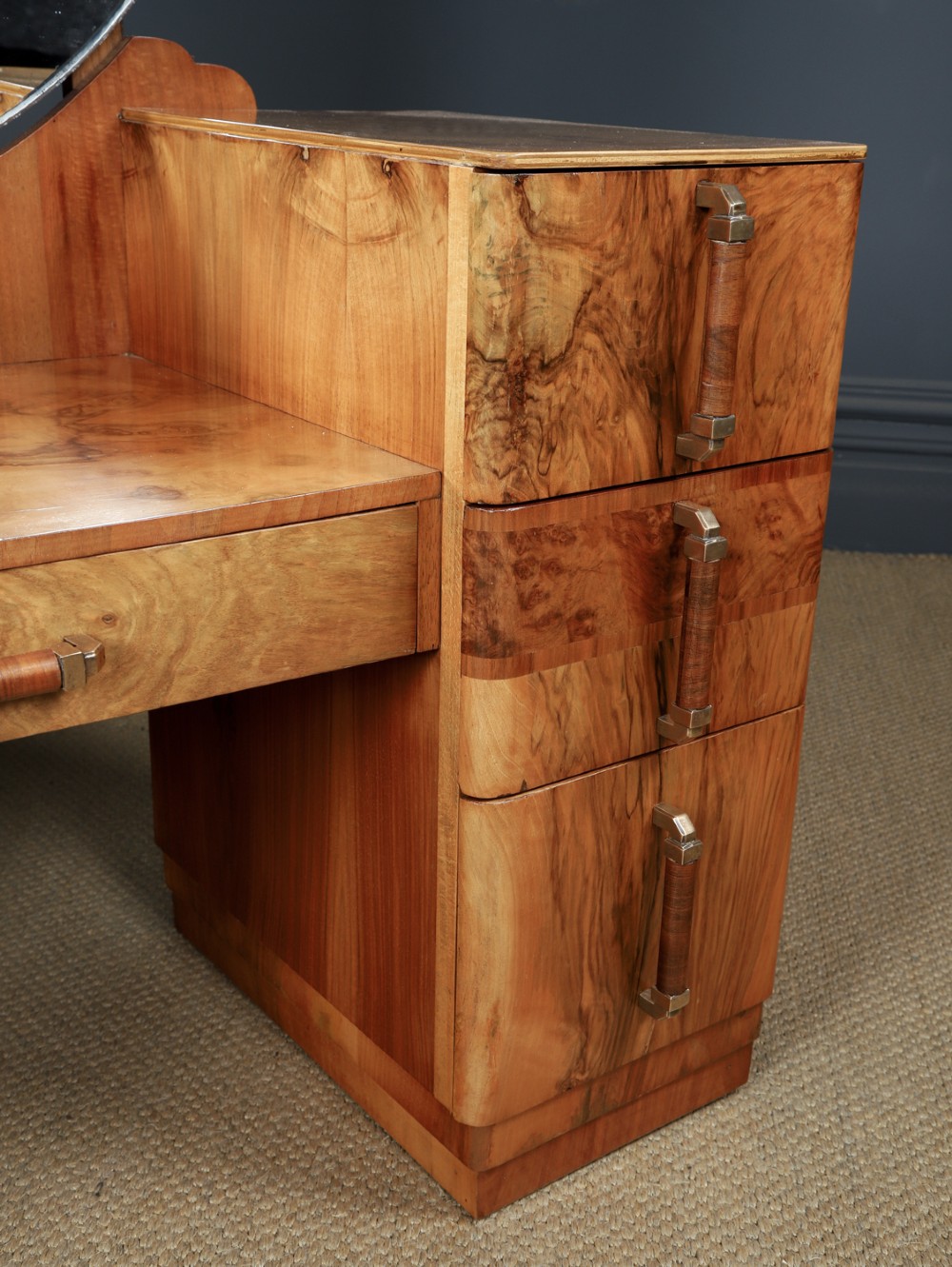 An Art Deco burr walnut pedestal dressing table featuring a large circular central mirror, a kneehole drawer, and three stacked drawers on each pedestal with vertical handles. View V