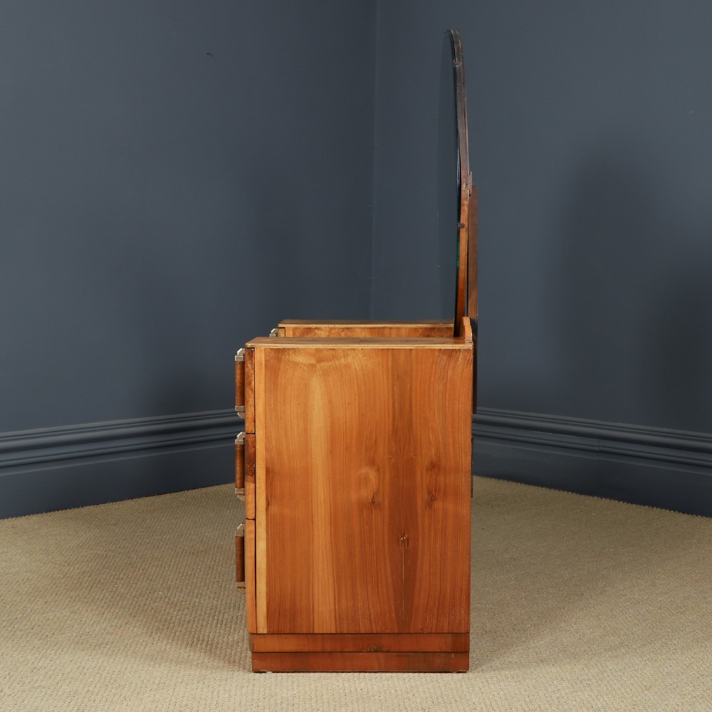 An Art Deco burr walnut pedestal dressing table featuring a large circular central mirror, a kneehole drawer, and three stacked drawers on each pedestal with vertical handles. View XII