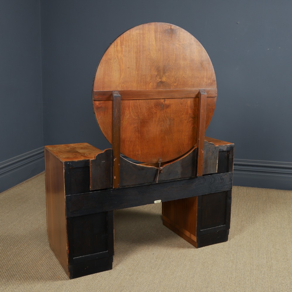 An Art Deco burr walnut pedestal dressing table featuring a large circular central mirror, a kneehole drawer, and three stacked drawers on each pedestal with vertical handles. View XIV