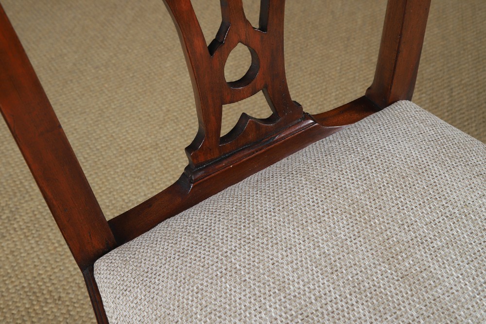 A Georgian mahogany side chair with a pierced carved back splat, square legs connected by stretchers, and a neutral textured seat upholstery. View III
