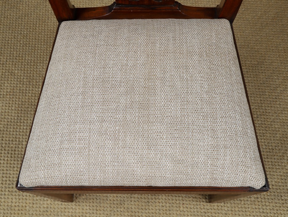 A Georgian mahogany side chair with a pierced carved back splat, square legs connected by stretchers, and a neutral textured seat upholstery. View IV