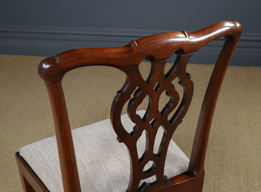 A Georgian mahogany side chair with a pierced carved back splat, square legs connected by stretchers, and a neutral textured seat upholstery. View X