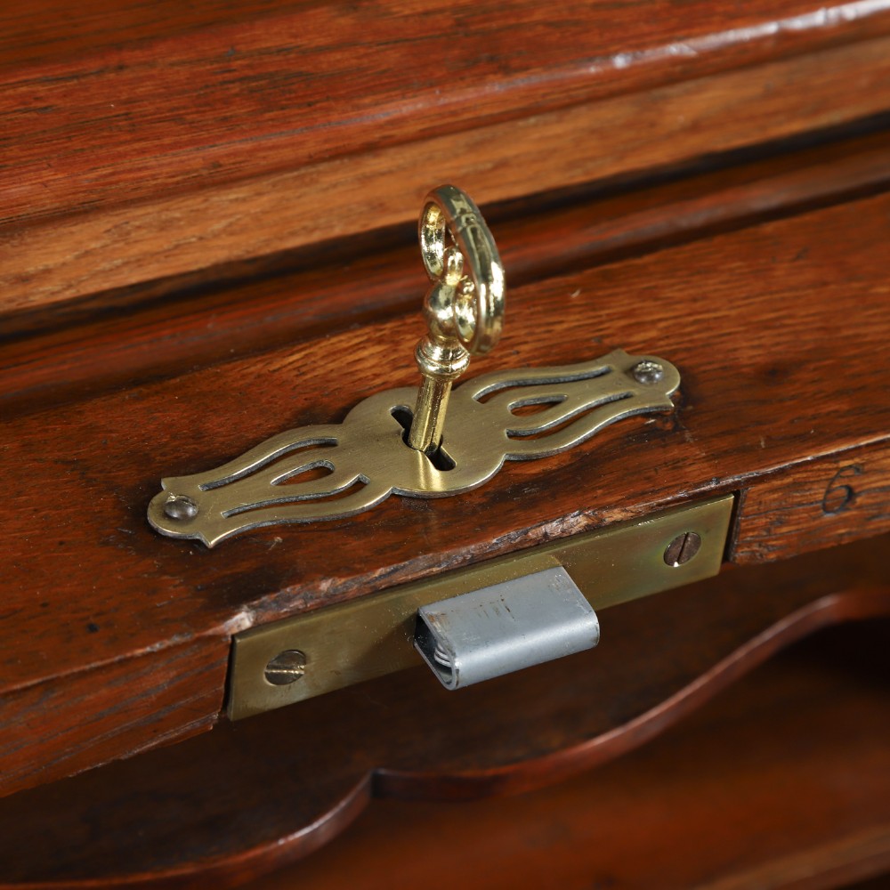 An Edwardian warm brown oak twin-pedestal rolltop desk featuring a flexible slatted wooden tambour shutter open to reveal internal pigeonholes above nine drawers with wooden cup handles. View VII