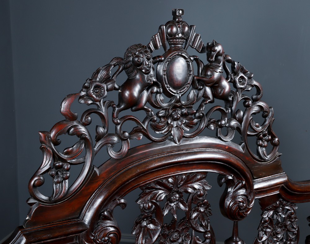 An Anglo-Indian mahogany four poster bed featuring carved turned posts, an ornate headboard, and a spindle footboard. View XI