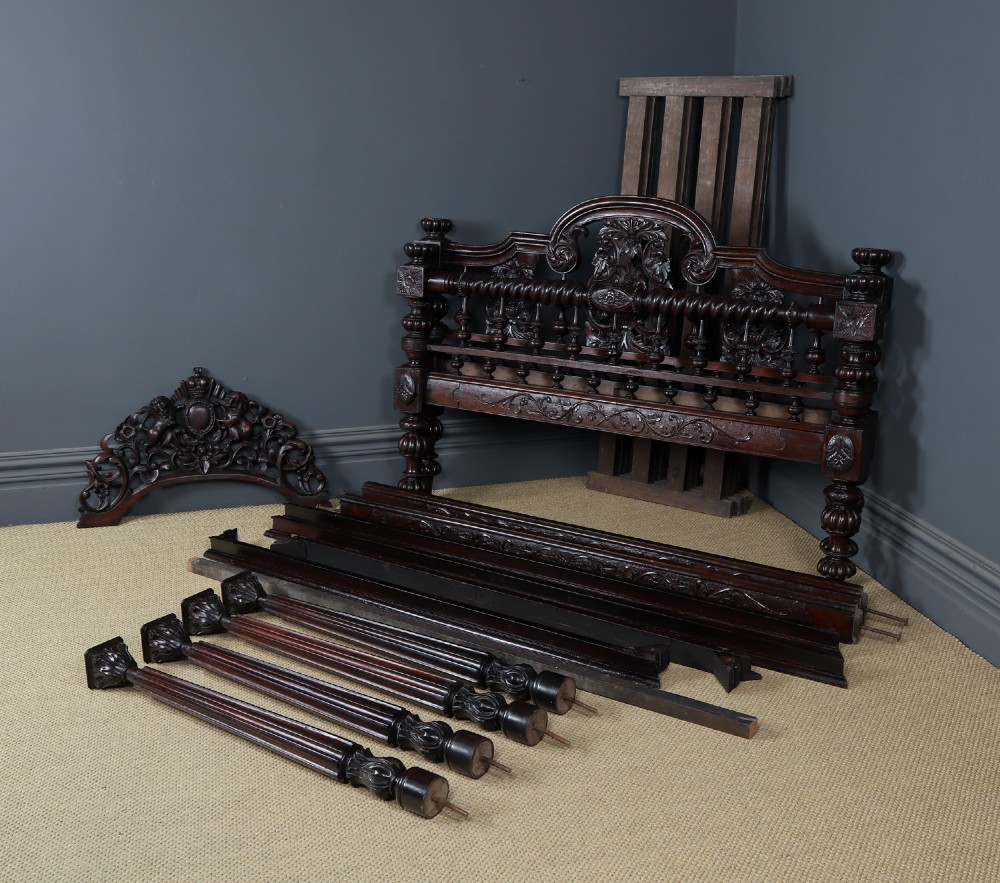 An Anglo-Indian mahogany four poster bed featuring carved turned posts, an ornate headboard, and a spindle footboard. View XIV